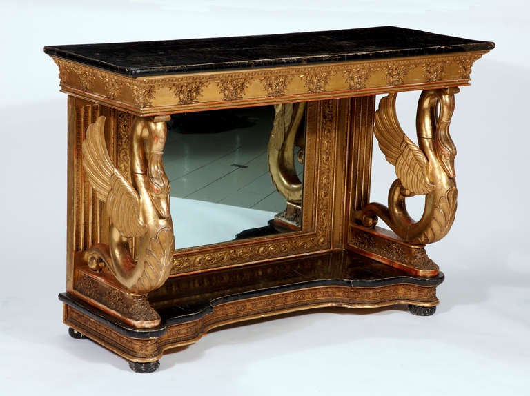 A Rare & Unusual Italian Giltwood Console
Early 19th Century

The faux marble top resting on a highly decorated frieze over a paneled and decorated back plate with a mirror with two swan form supports on the front all over a plinth with bun