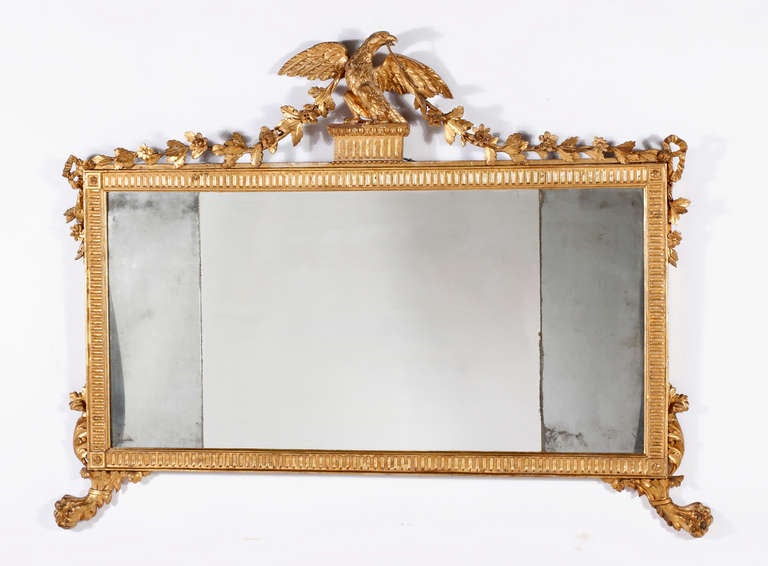 A Fine George III 
Giltwood Mirror
18th Century

the rectangular mirror plates surrounded by a carved motif frame with a central eagle flanked with flowering garlands and on either side of the frame ,ending with carved  paw feet.

Height 44 in. 