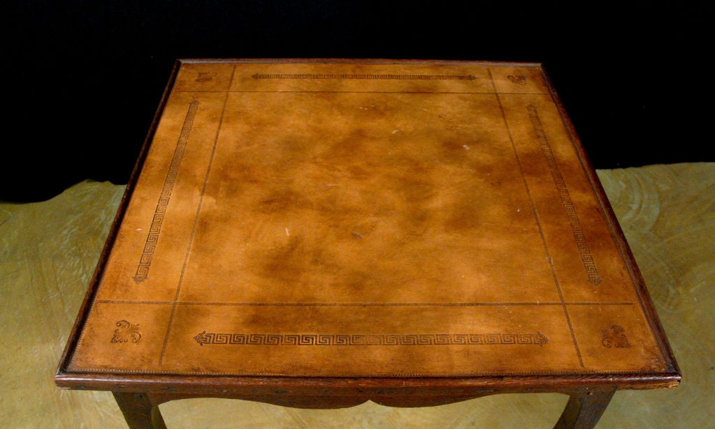 The square top with a tooled leather surface above four drawers raised on cabriole legs ending with sabots.