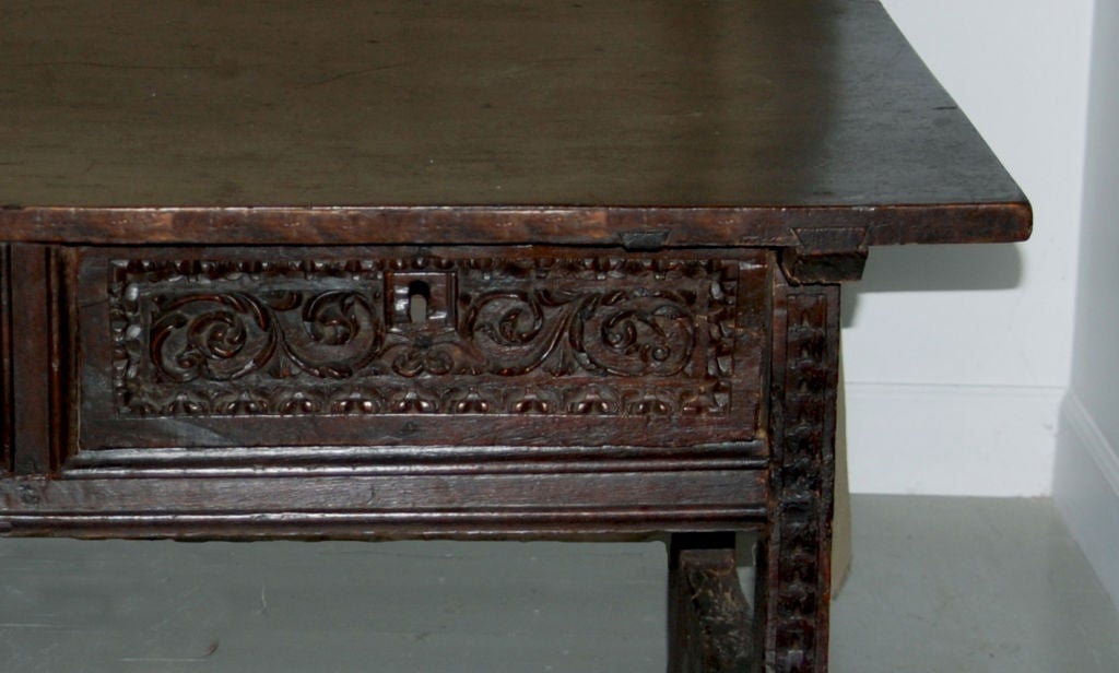 The rectangular top above two carved frieze drawers, resting on carved legs joined by a scalloped stretcher.
