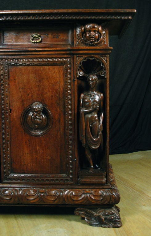 A Rare Italian Renaissance<br />
Walnut Credenza<br />
Venice<br />
17th Century<br />
In the Manner of  the Sculptor Andrea Brustolon (1662-1732)<br />
<br />
The rectangular top with a carved edge over two drawers and two cupboard doors with
