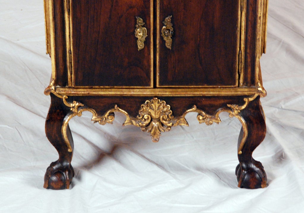 With a dish top over a single drawer, over a pair of cupboard doors, with decorated and carved frieze, all resting on four cabriole legs ending in paw feet