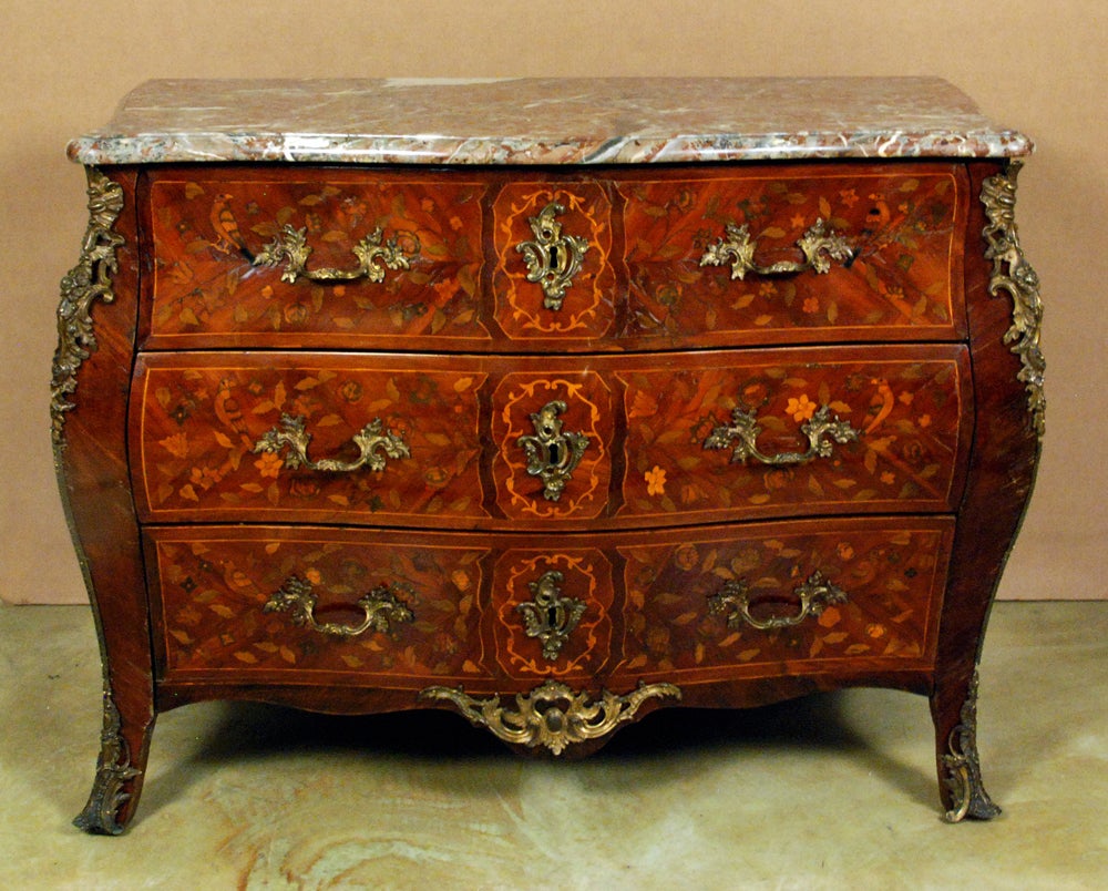 The shaped marble top above a bombe case with ormolu mounts, highly decorated throughout with marquetry with three drawers, on short cabriole legs.
 
Provenance: Private collection, New York, Le Trianon Fine Art & Antiques, Sheffield, Ma.