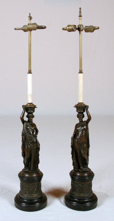 A Fine Pair of French Bronze Classical Figures 
Now Mounted as Lamps
By Louis Valentin Elias Roberts
French 1821-1874

Signed. L.V.E. Robert, each a standing draped classical woman mounted on round black marble plinth with bronze frieze of