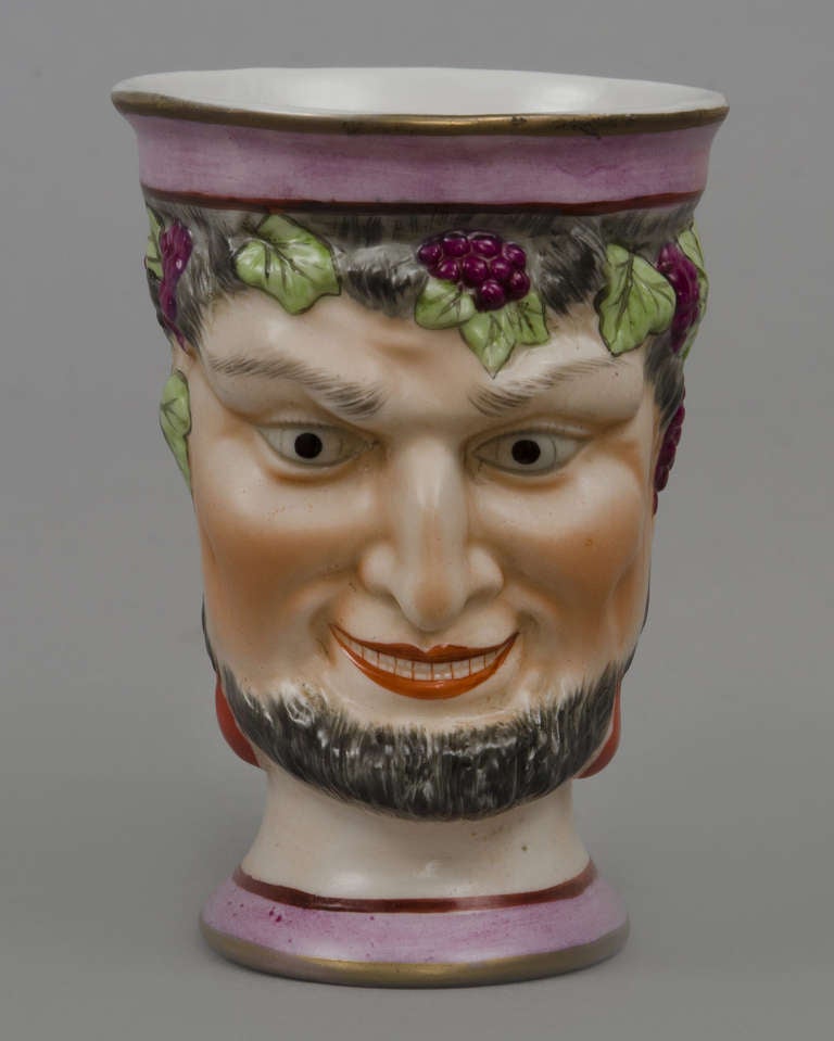 English  Staffordshire satyr jug molded with a mask of Bacchus, decorated with gilt rim and handle, puce-colored borders top and bottom and inside handle, grapes and leaves.  Circa 1870
    
    Item #1591