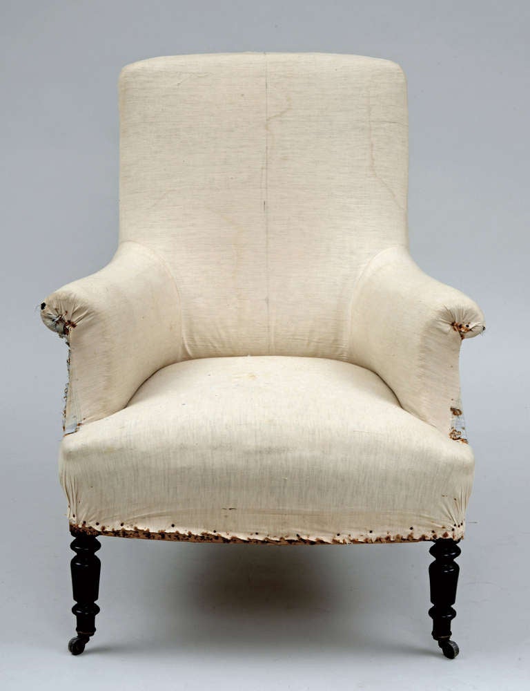 French Napoleon III square-backed upholstered scroll armchair raised on turned ebonized legs ending in casters. Original muslin underlining ready for finished upholstery. This chair is incredibly comfortable.  Great for reading.

Item ##7299
