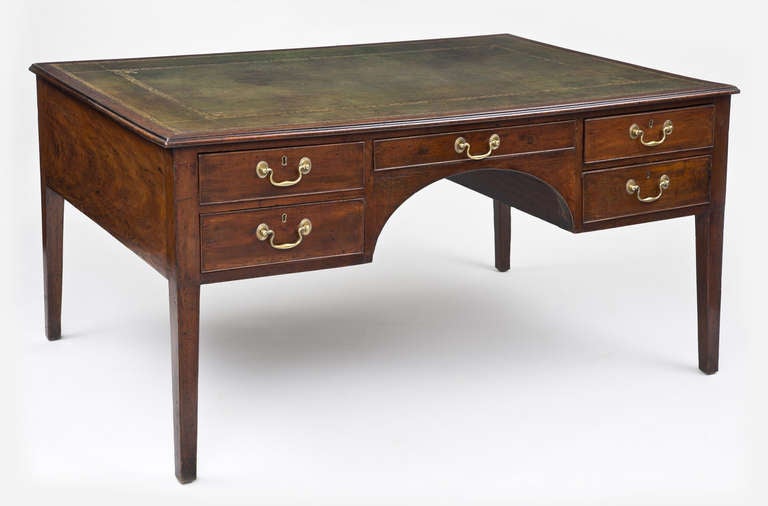 George III mahogany partners writing table/desk, the rectangular top with molded edge, having ten drawers, olive green gilt-tooled leather writing surface, frieze drawer in centre flanked by two drawers on each side of arched knee hole, the centre