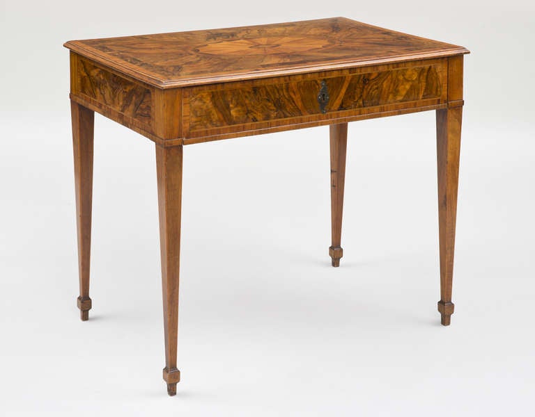 Northern Italian (Piedmont) boldly figured walnut and rosewood inlaid table, the top centered by a pear wood shell pattern within a narrow rosewood oval banding, the frieze with one long drawer fitted with a velvet lined interior for flatware,