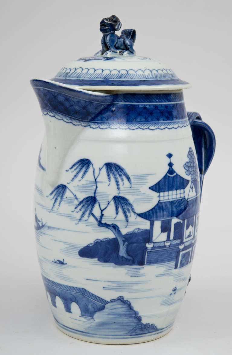 Large Chinese export Canton porcelain blue and white cider jug and cover with foo dog finial, bold and well painted riverscape decoration, perfect cross-strap reeded handle with ornate foliate and floral terminals.

 