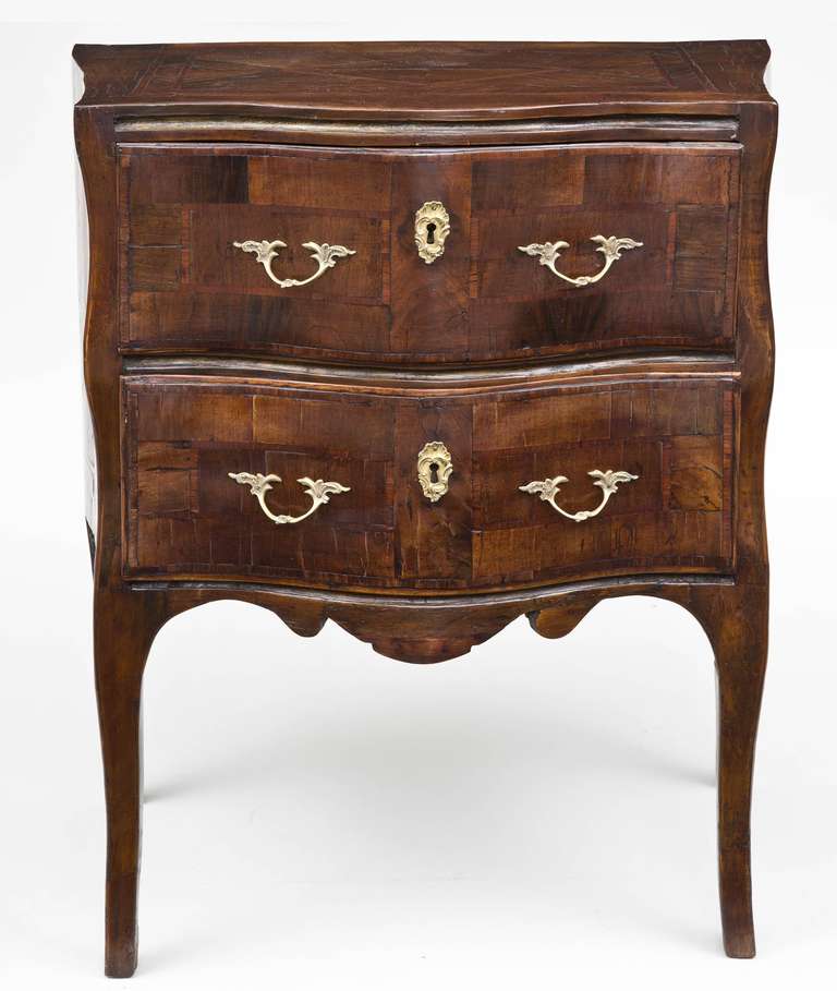 Very elegant Sicilian Rococo kingwood parquetry small commode or commodini of bombe outline with two drawers with gilt brass replaced handles and escutcheons, parcel gilding between the drawers, shaped apron, raised on graceful hipped cabriole legs.