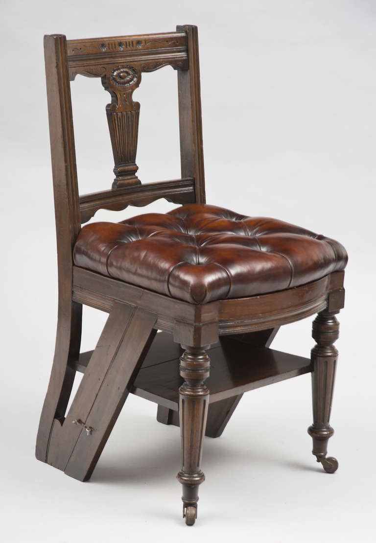 Victorian mahogany carved metamorphic chair and library steps, the curved fluted top rail above rosette and urn-form splat, the  brown buttoned leather seat removes to reveal the hinged seat, opening to form three steps, raised on fluted and turned
