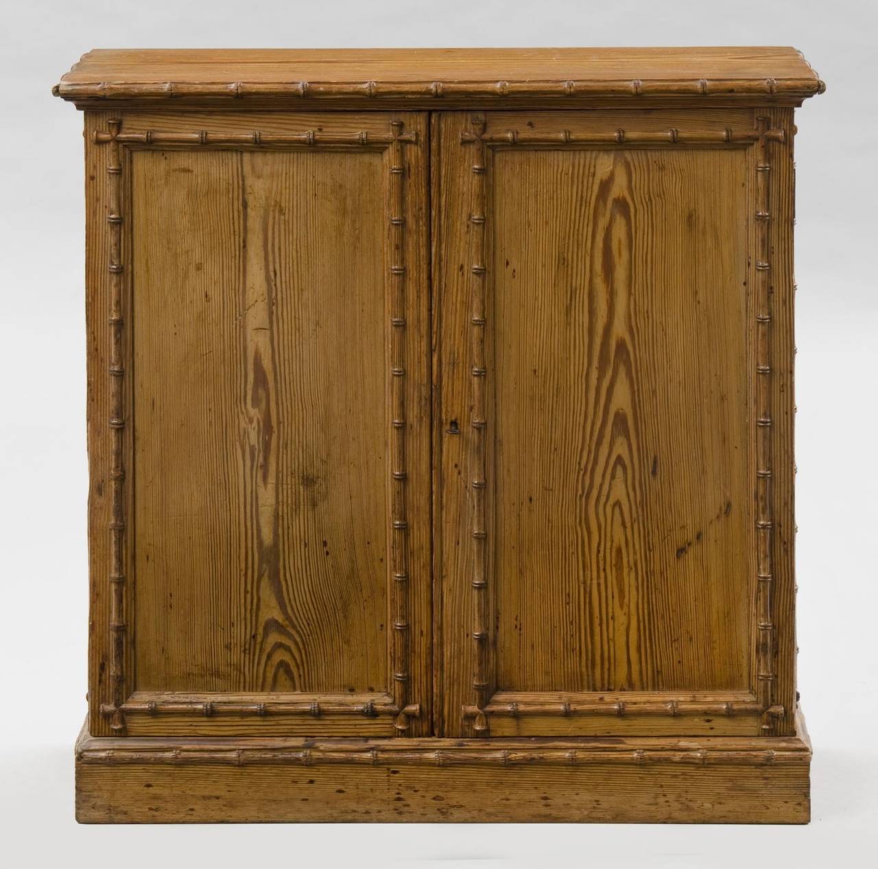 Pine two-door cupboard or cabinet with carved faux bamboo moldings around the top edge, the doors, sides and base. The doors open to reveal two adjustable shelves.

Item #7005