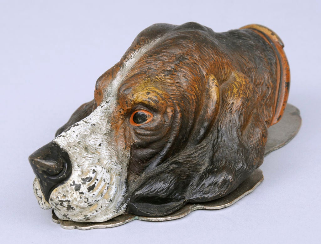 Vienna cold paint bronze letter clip in the shape of a dog's head. The head is spring hinged to a flat brass plate.