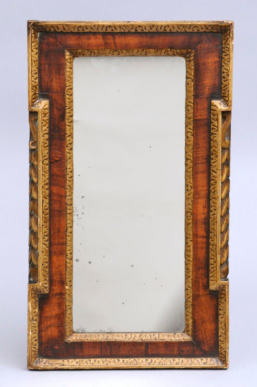 George II walnut veneered mirror with parcel-gilt and carved leaf borders and side decoration.
