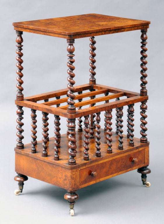 Early Victorian burr walnut tall standing Canterbury with superstructure, barley twist spiral supports and uprights, the lower section with three compartments, frieze drawer, raised on turnip-shaped feet on porcelain casters.