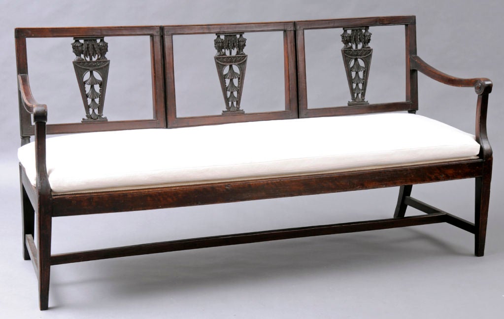 Italian walnut settee with three-carved and pierced chinoiserie motif splats depicting Chinese inspired heads above a trapezoid shape with leaves and hat shapes, over scroll end arms, straight tapering front legs, splay back legs connected by