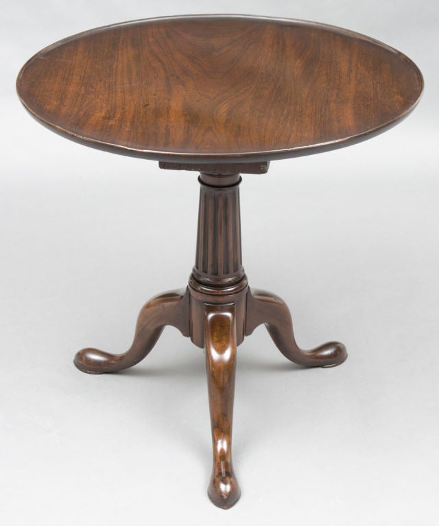 Early George II walnut tilt-top tripod table with circular dished top revolving on a birdcage support, fluted and ring turned pedestal on cabriole legs and pad feet.