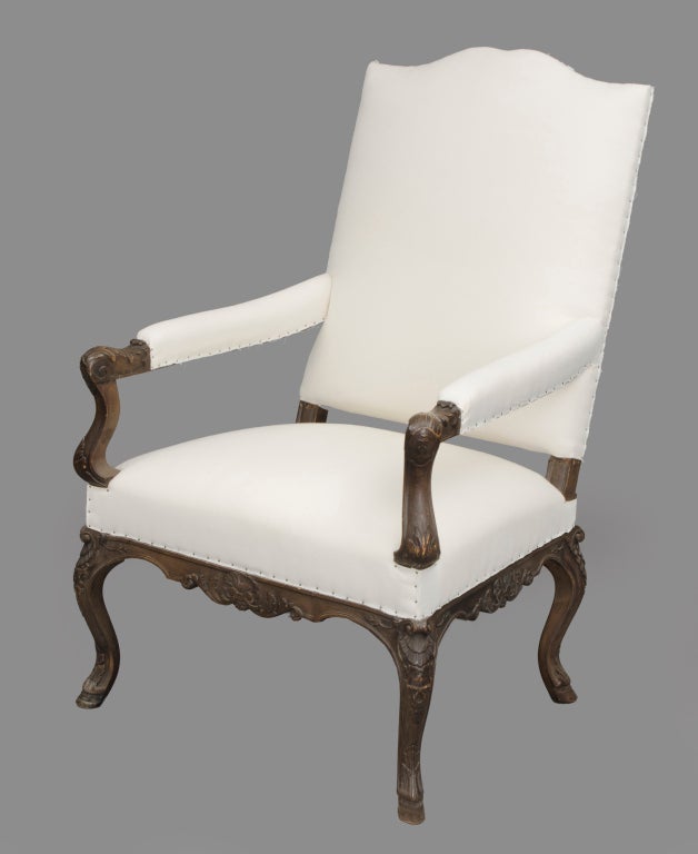 French walnut open arm bergere with shaped back crest, upholstered arm pad extending to carved acanthus leaf S-scrolled arm supports, hipped cabriole legs front and back with carved shell motif on knees ending in hooved feet. Seat apron also having