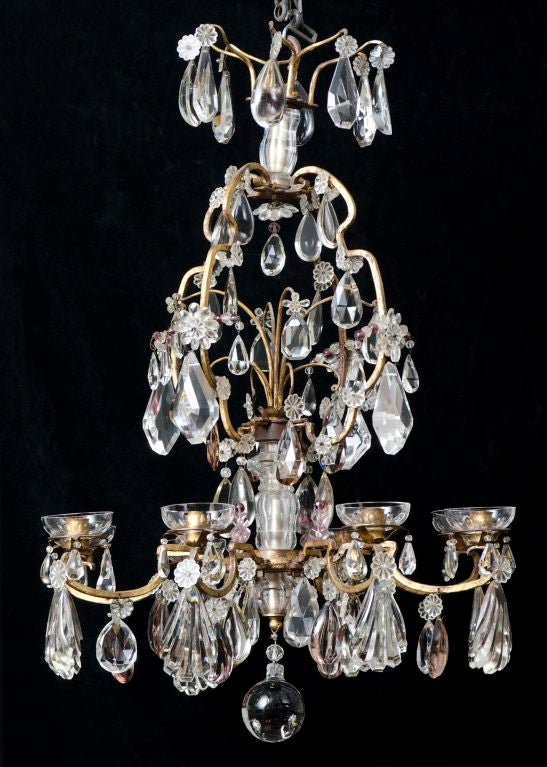 A large very good quality eight-light chandelier with gilt metal frame and large cut-crystal shell-, diamond- and tear-shaped clear and amethyst-colored drops. Attributed to Baguès. It has been electrified.