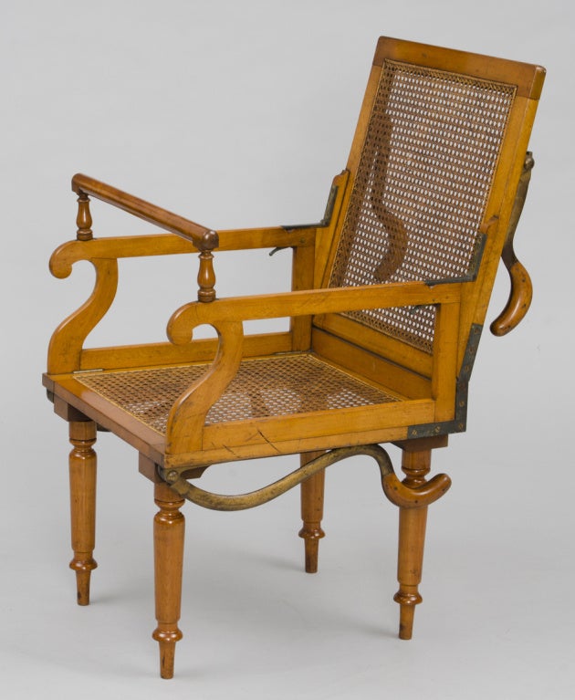 Victorian caned satin birch campaign traveling or invalid’s armchair with front and rear steel carrying handles that unfold, the legs unscrew from the frame for easy transport and the hand rail is removable. The trigger mechanism in the corner of