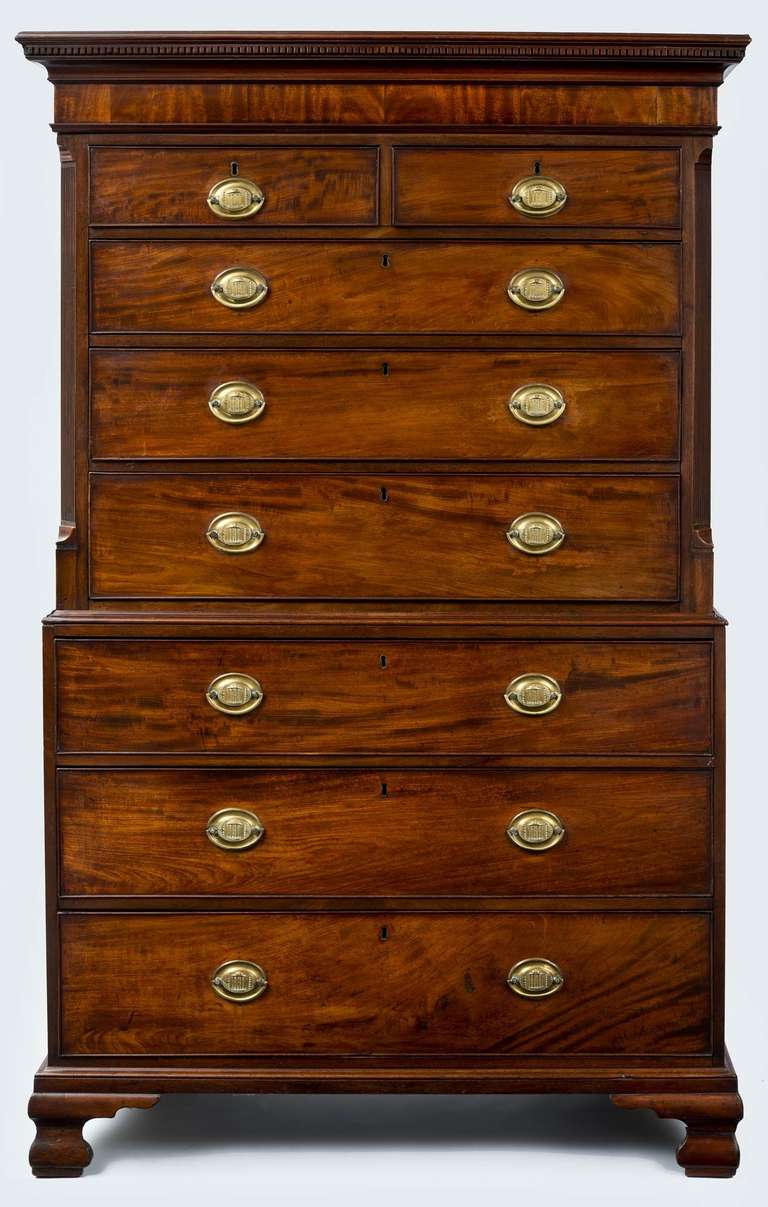 An early George III mahogany chest on chest, the rectangular top with dentil molding and cross-banded cornice above two short and three long graduated, cock beaded drawers flanked by fluted quarter pilaster columns, the base with three long