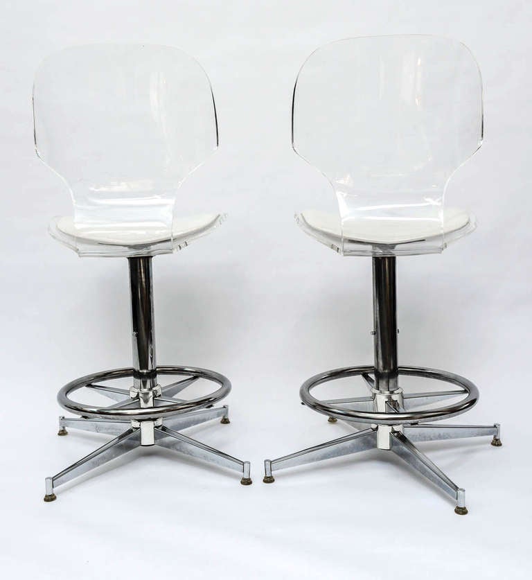 This Pair of 1970's Sculptural lucite and Chrome Bar Stools chairs are very comfortable and will lighten up any dining or entertaining area.  The lucite seats curve in an ergonomic fashion for greater back support.  Each stool includes a molded,