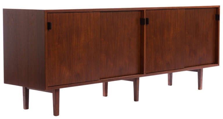 A superlative example of Knoll design, this beautifully crafted sideboard has four sliding doors with newly fashioned top grade leather pulls and six tapered legs.  Entirely restored in a beautiful satin finish.