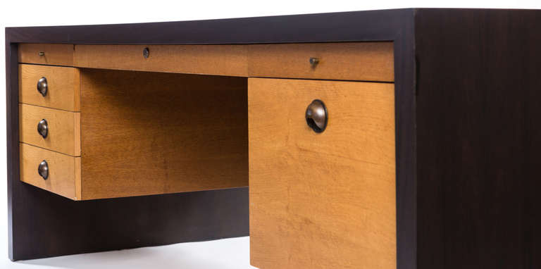 Meticulously restored to near original showroom perfection this powerfully commanding piece is made of golden oak and rich rosewood, decorated with ergonomic bronze pulls and finished in a soft satin luster.  Evoking images of prominent 20th Century