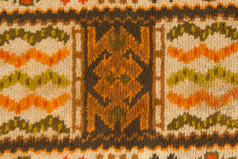 Handwoven rug from Portugal and made in the 1960's. It displays a symmetric pattern focused around the tectonic central medallion.