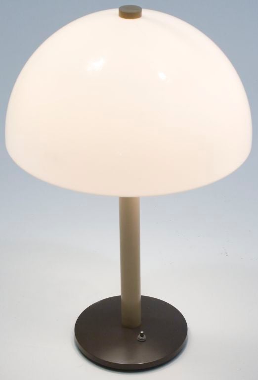 Modern desk lamp with molded acrylic dome-shaped shade, acrylic riser and base and double socket.
