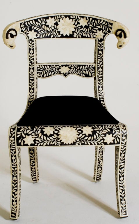 This exquisitely detailed version of the classic Klismos chair features Rajasthan bone inlay in a floral pattern. The back of the chair is finished with two ram's heads. The seat is upholstered in black burn out velvet.