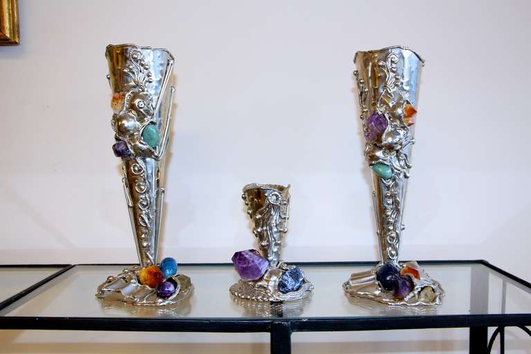 A nice group of three vases, two taller vases and a shorter one, which is 5.5 inches tall and 4 inches in diameter. The dimensions given below are for the larger vases. The metal is probably a nickel silver and the stones are semi-precious with