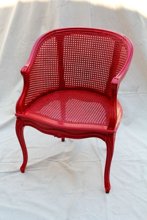 A nice painted french cane chair. Solidly built and newly painted a bright red. It is sturdy and features some nice carved details.