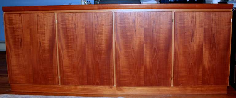 A nice teak sideboard or credenza made by scovby of Denmark. It has 4 doors with shelves in three of them and drawers in the left one.  Bears the scovby label on the rear.