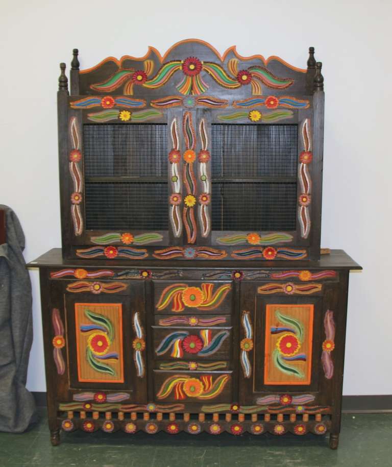 A wonderfully hand painted folk art cabinet, most likely Mexican. Comes in two parts.