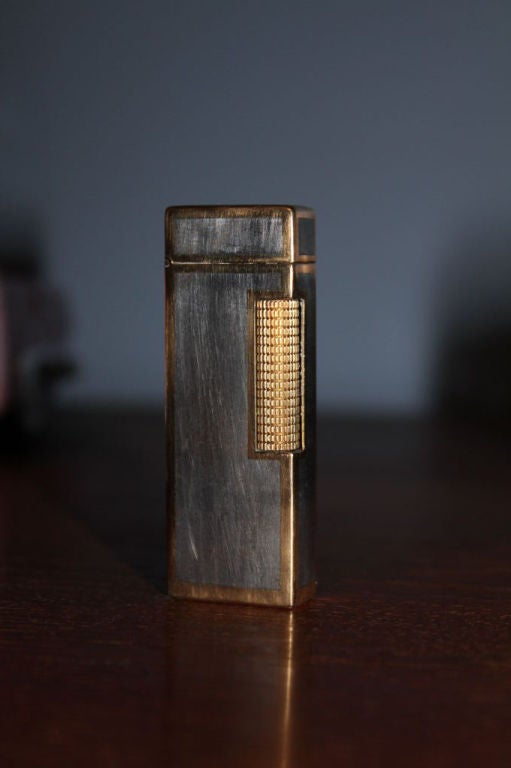 Cartier labeled 18k lighter marked Italy with a slide that is also monogrammed that covers the dunhill registry and lighter filling parts. It is marked Switzerland underneath. While the gold metal tests as 18k we believe the white parts are silver