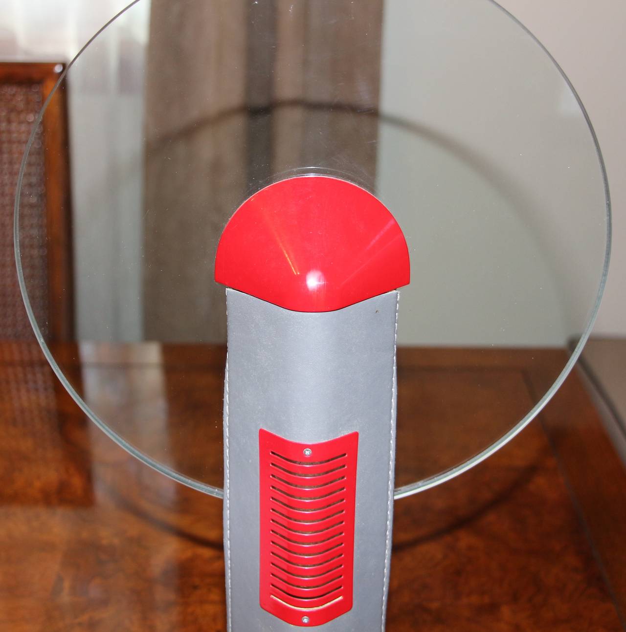 An unusual Relco Italia halogen table lamp with a dimmer on off switch. The lamp is made out of red enamel metal, grey leather, and a glass disk. The lamp is in working order.