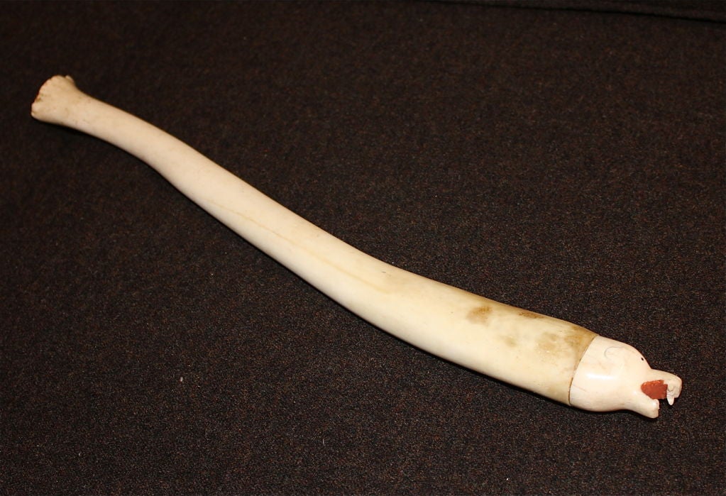An interesting and rather large Inuit Native American Eskimo carving or ornamental piece made of a fossilized walrus oosik and carved walrus tusk for the head. For those who don't know, an oosik is a male mammal reproductive <br />
organ cartilage.