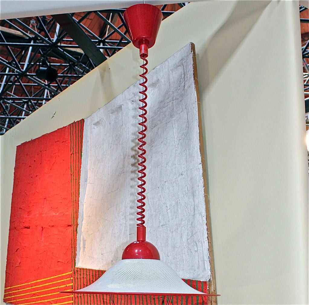 An unusual retractable Italian pendant lamp in a vibrant shade of red. The retractable parts are all marked Italy. Not sure who designed this but it is ready to hang. Length is adjustable very easily from approx 24 inches to over 60 inches.