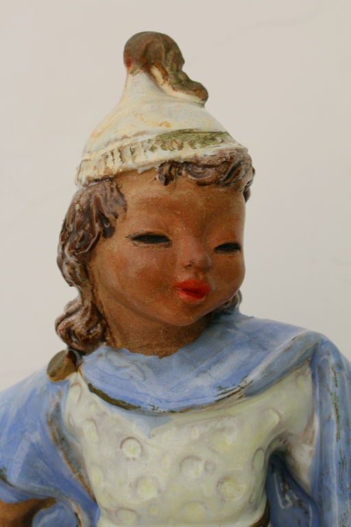 A wonderful Austrian Secessionist glazed terra cotta figure, which is monogrammed on the base and incised Wien for Vienna. Very much in the style of the Wiener Werkstatte or Susi Singer. It bears an old partial John Wanamaker label. There is an