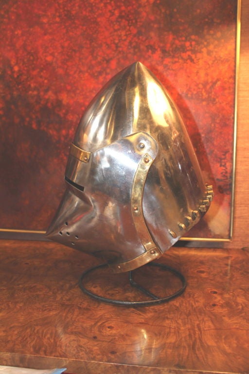 A great medieval style helmet out of a movie prop house. They have been in storage for many years. These props are of extremely high quality and this one has a hinged front. It is wearable and makes a great decorative accessory. The stand is new.