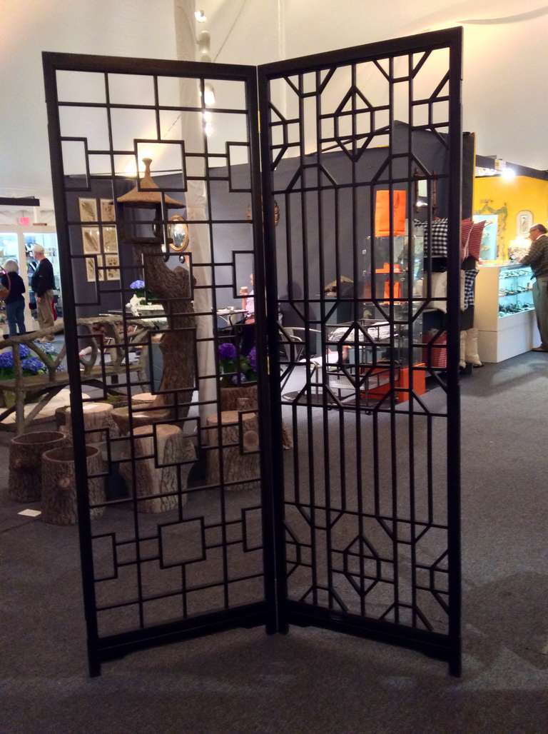 A beautiful Asian wood geometric screen or room divider. New hinges have been put in in place of the old ones. There are mortised areas on both open edges meaning that this was part of a larger screen. These areas have been filled. This very
