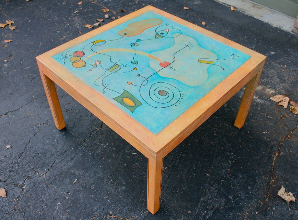 Whimsical faux painted table with a miro like painting on top.