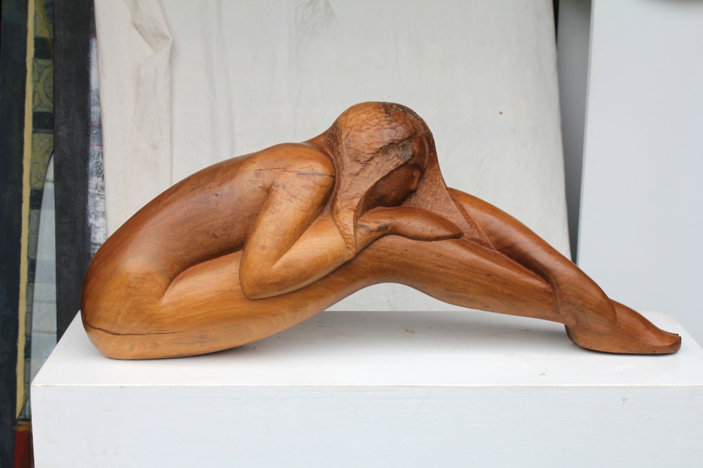 An extremely well done wood carving of a nude woman stretching. It is well executed and quite lovely. The wood has beautiful graining and nice patina.