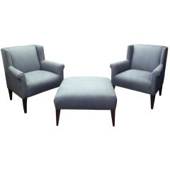Pair of stylized Baker wing chairs with an ottoman