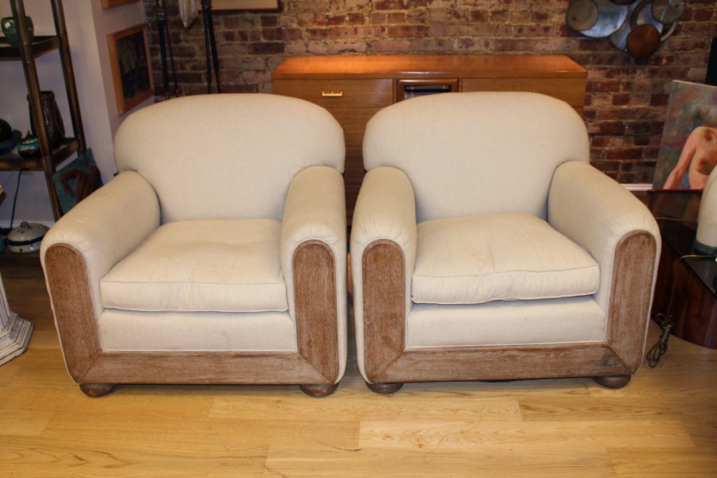A wonderful pair of period 1930-1940's club chairs re-upholstered in Belgian Linen. They feature cerused oak fronts and legs. We left one of the bottom duvets loose to show the Argentinian burlap used in the construction of the chairs. They are