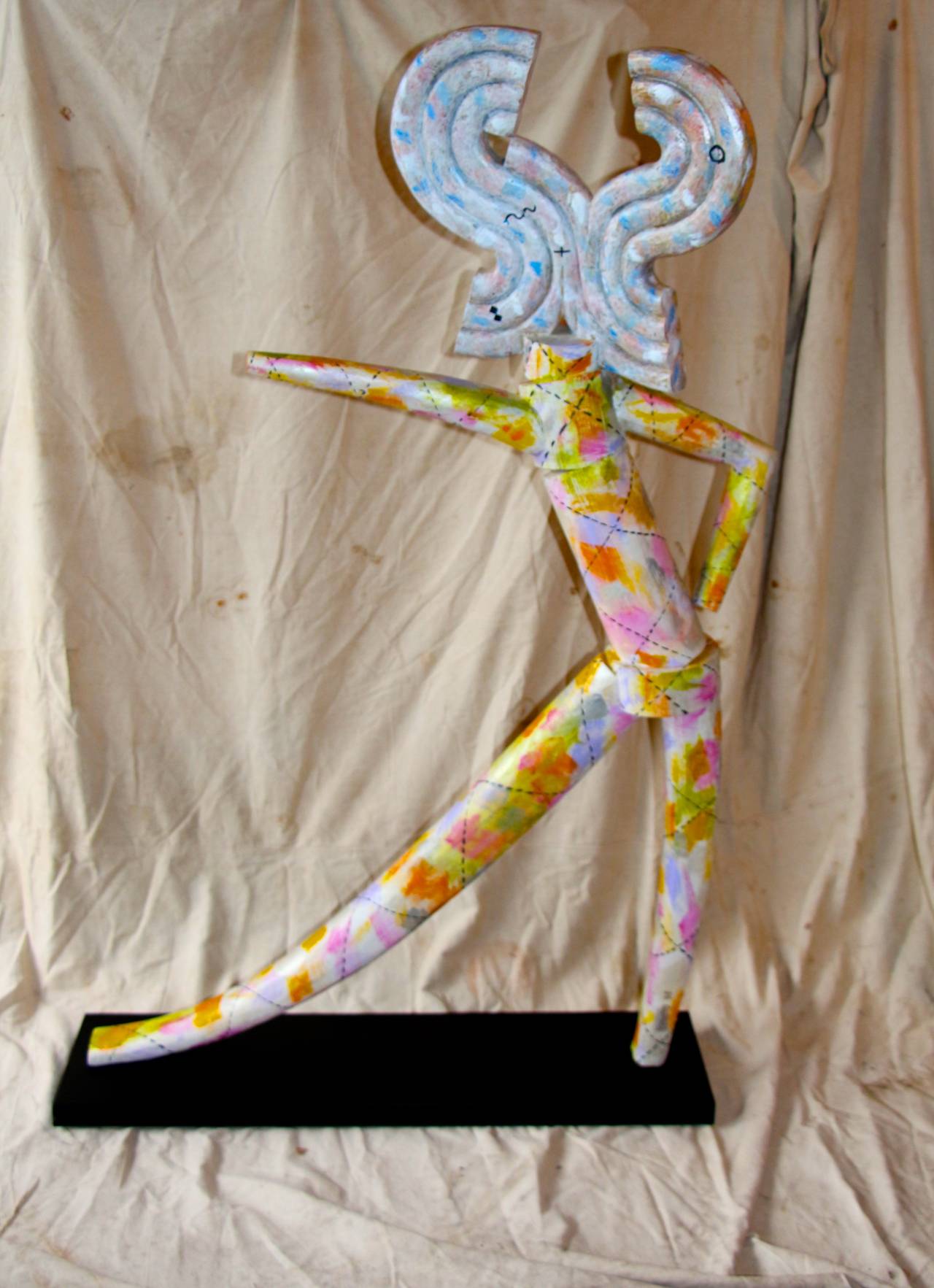 A great whimsical colorfully painted lifesize wood sculpture of a nude. The base has been re-painted black. It is signed on the leg Schumm, 1995. 
The artist's statement from a 2007 article follows;
Fred Schumm does not view life through