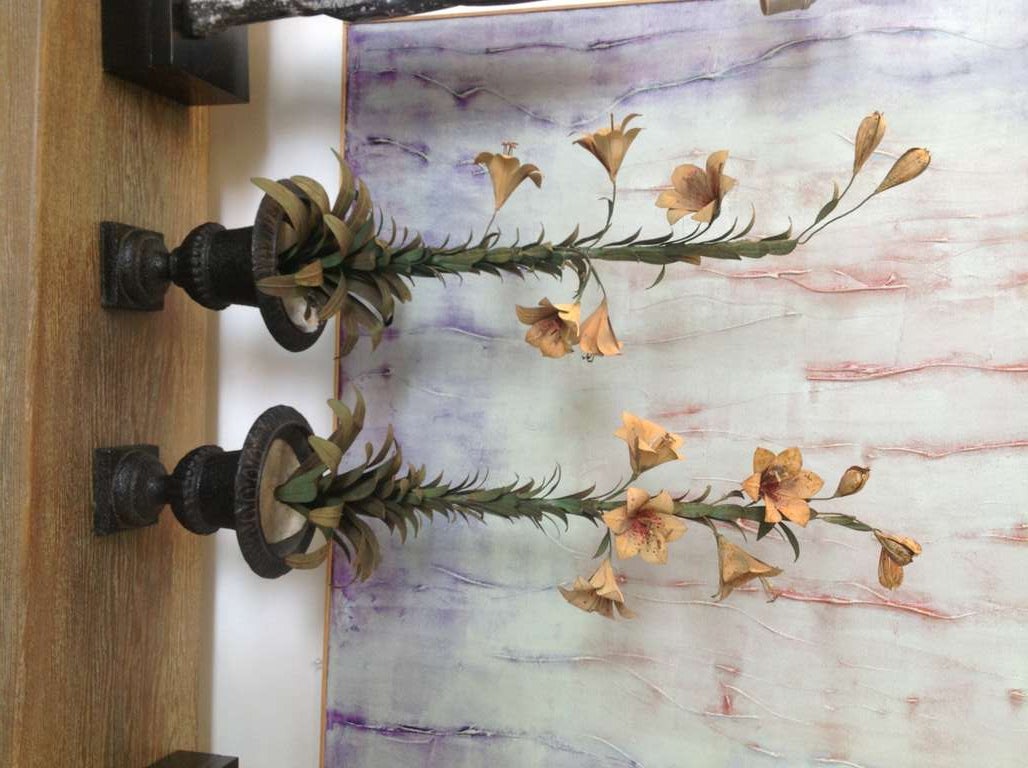 A pretty pair of tole and iron painted floral arrangements or garnitures. They probably date to to the 1920-30's. they have an age appropriate amount of paint loss. The flowers are held onto the main stem by tightly wound wire, detailed in the