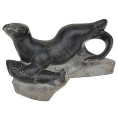 Ancienne sculpture inuit d'un phoque ou d'un morse attrapant un poisson