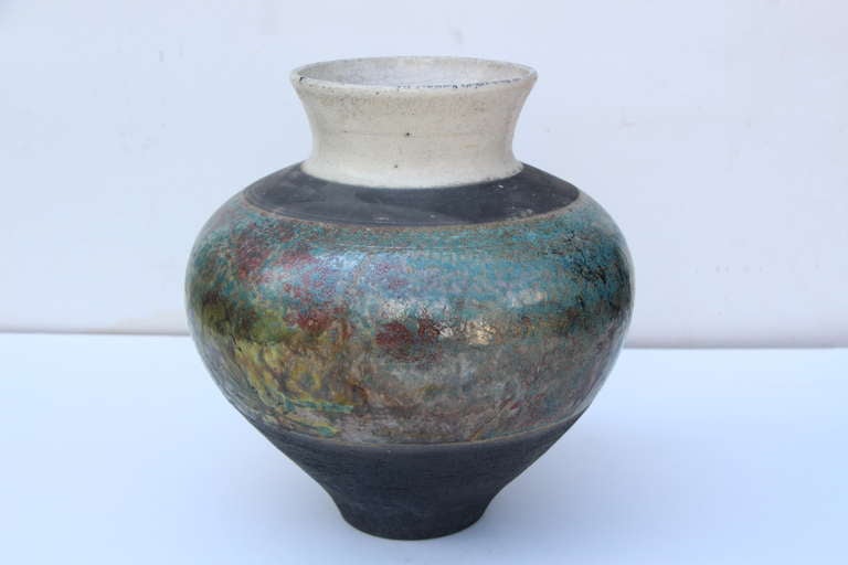 A pretty Raku fired vase by the noted potter Lew Ayres. The paper was found inside the vase. The paper pictured will accompany the vessel which gives a background on Mr. Ayres and a brief description of the raku process. 